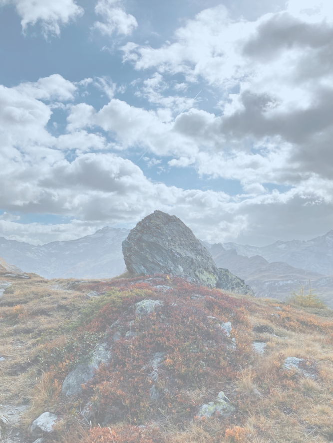 large rock with clouds in the background