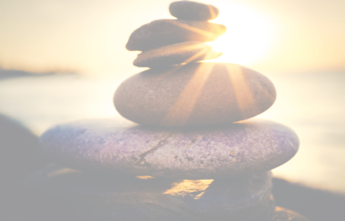 stacked rocks on a beach at sunset